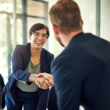woman shaking man's hand in workplace setting
